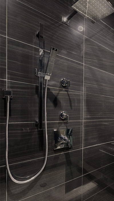 black tiled shower with modern rain showerhead